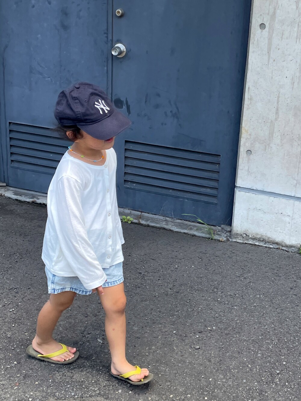 ブルー系のデニムパンツ、ブラウン系のサンダル、ホワイト系のTシャツ/カットソーを着用したキッズの夏コーディネートの5枚目の写真