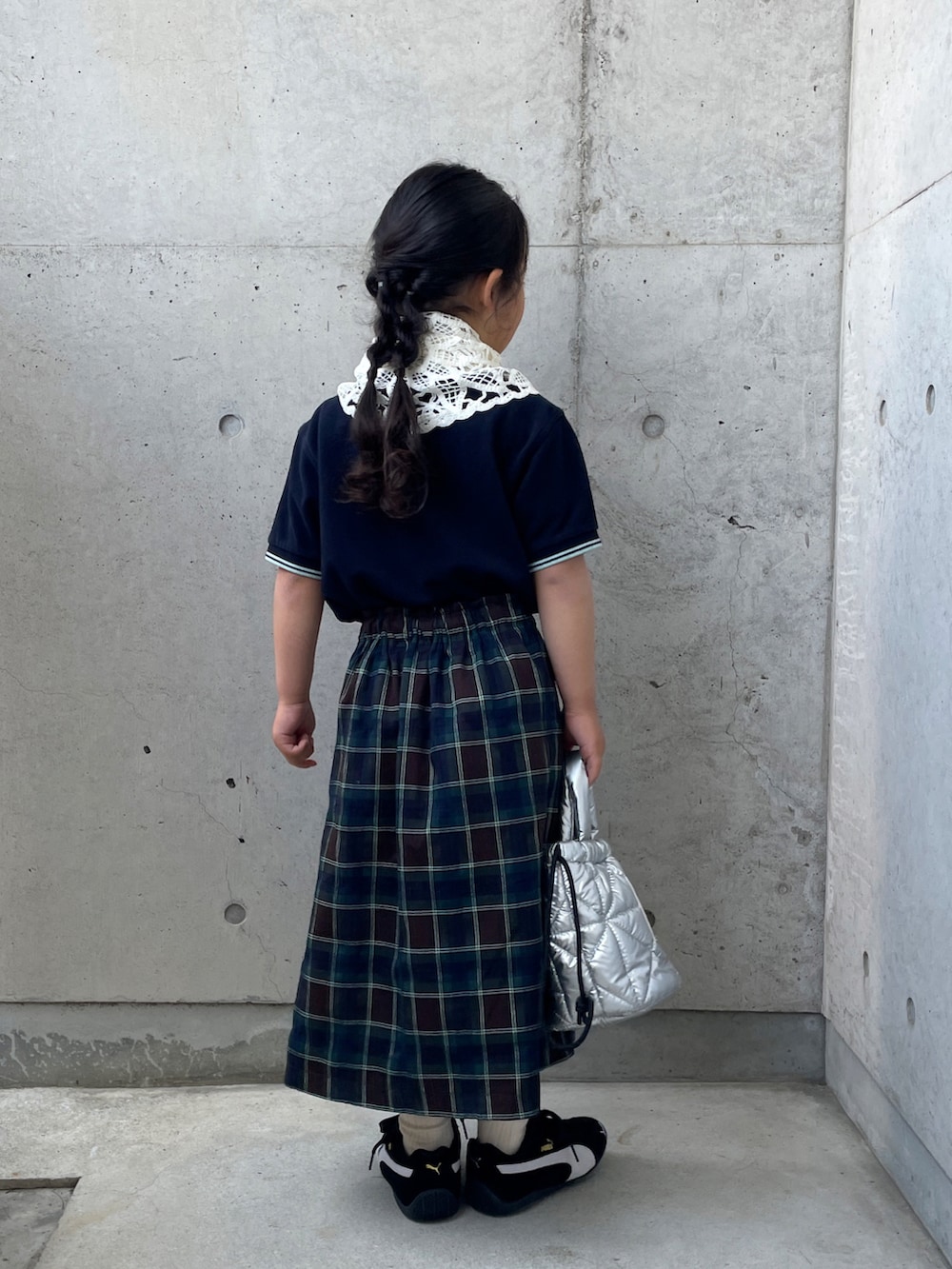 ブラウン系のスカート、ブルー系のポロシャツ、ブラック系のスニーカーを着用したキッズの春コーディネートの5枚目の写真