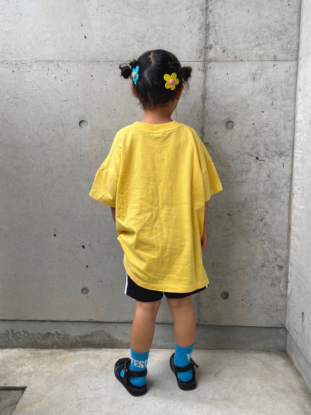 イエロー系のTシャツ/カットソー、ブラック系のその他パンツ、ブラック系のサンダルを着用したキッズの春コーディネートの3枚目の写真