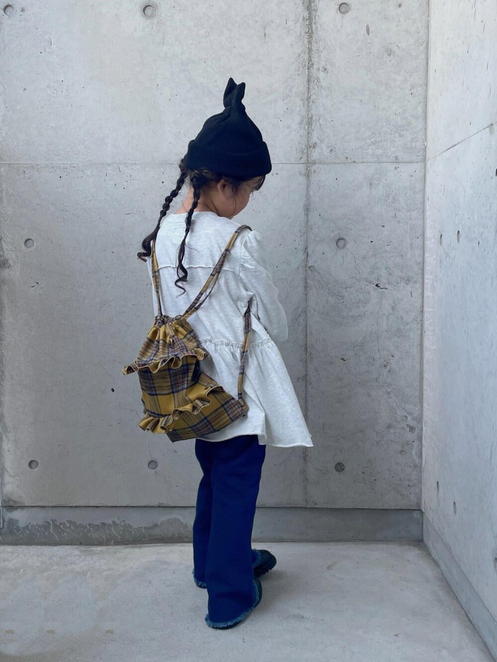 ブルー系のデニムパンツ、グレー系のワンピース、イエロー系のバックパック/リュックを着用したキッズの夏コーディネートの3枚目の写真