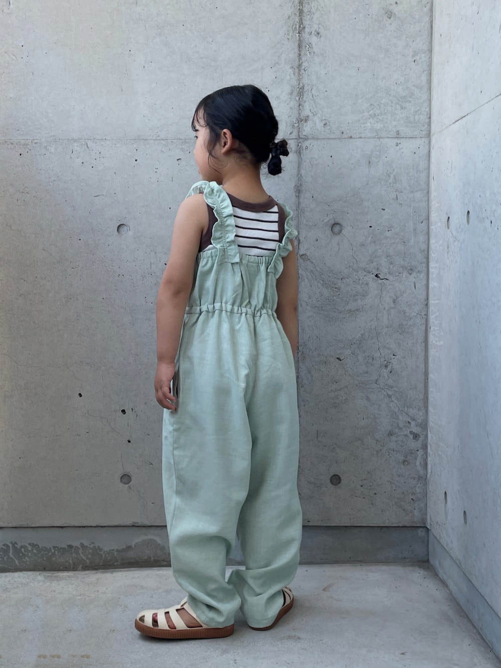 ホワイト系のサンダル、グリーン系のつなぎ/オールインワン、ブラウン系のタンクトップを着用したキッズの夏コーディネートの3枚目の写真
