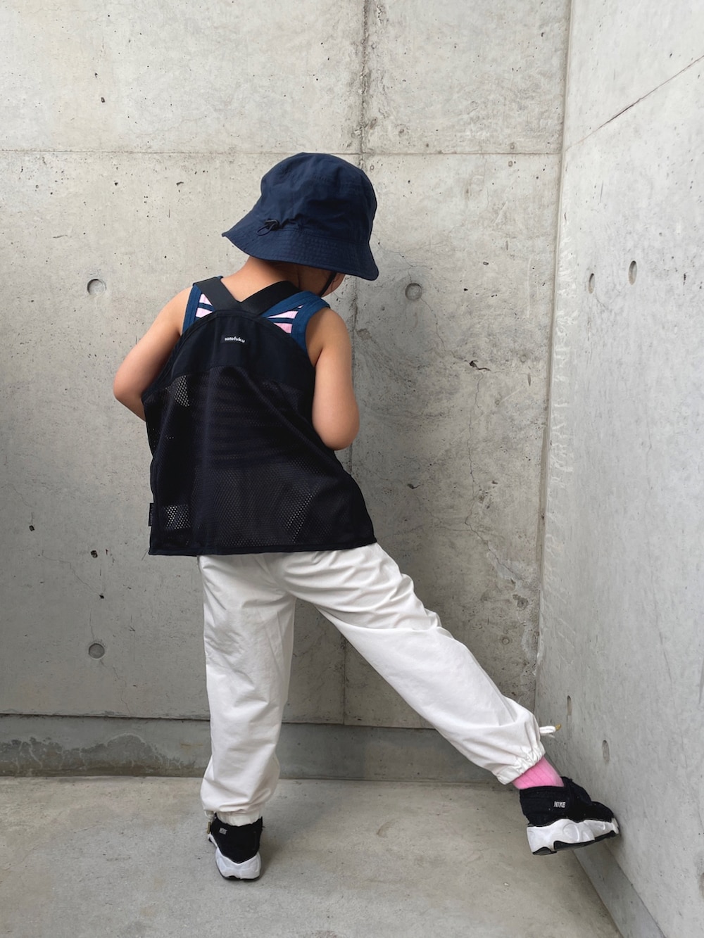 ブルー系のタンクトップ、ブラック系のベスト、ホワイト系のカーゴパンツを着用したキッズの春コーディネートの4枚目の写真