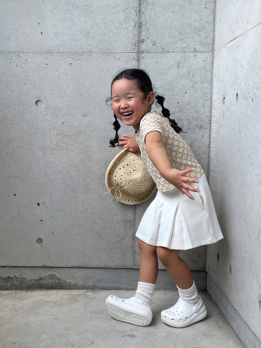 ベージュ系のトップス、ブラック系のスカート、ホワイト系のサンダルを着用したキッズの夏コーディネートの2枚目の写真