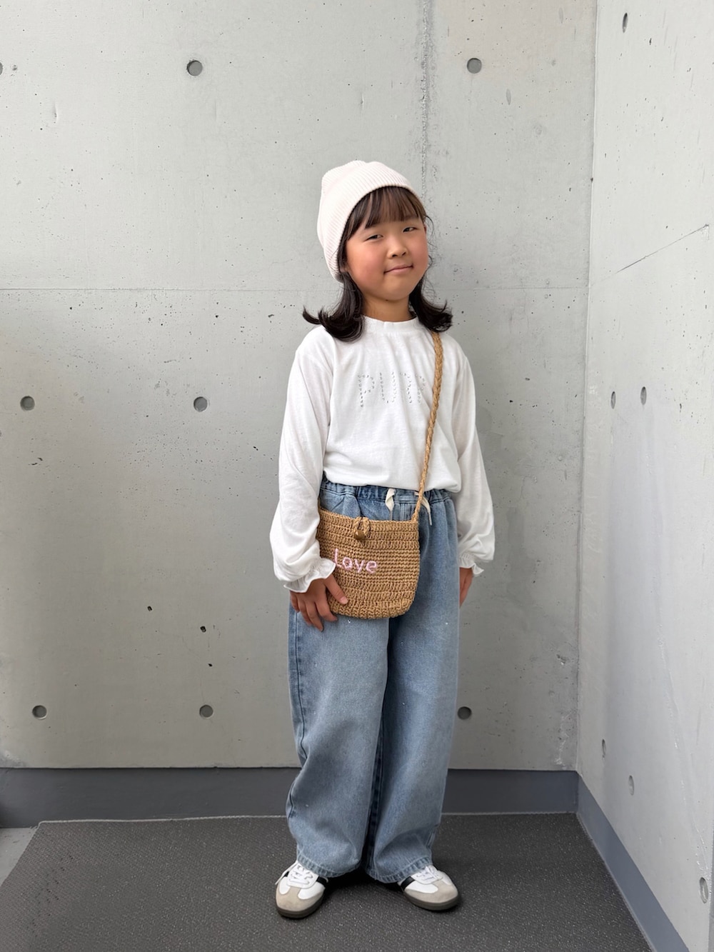 ベージュ系のショルダーバッグ、ホワイト系のTシャツ/カットソー、ブルー系のデニムパンツを着用したキッズの秋コーディネートの4枚目の写真
