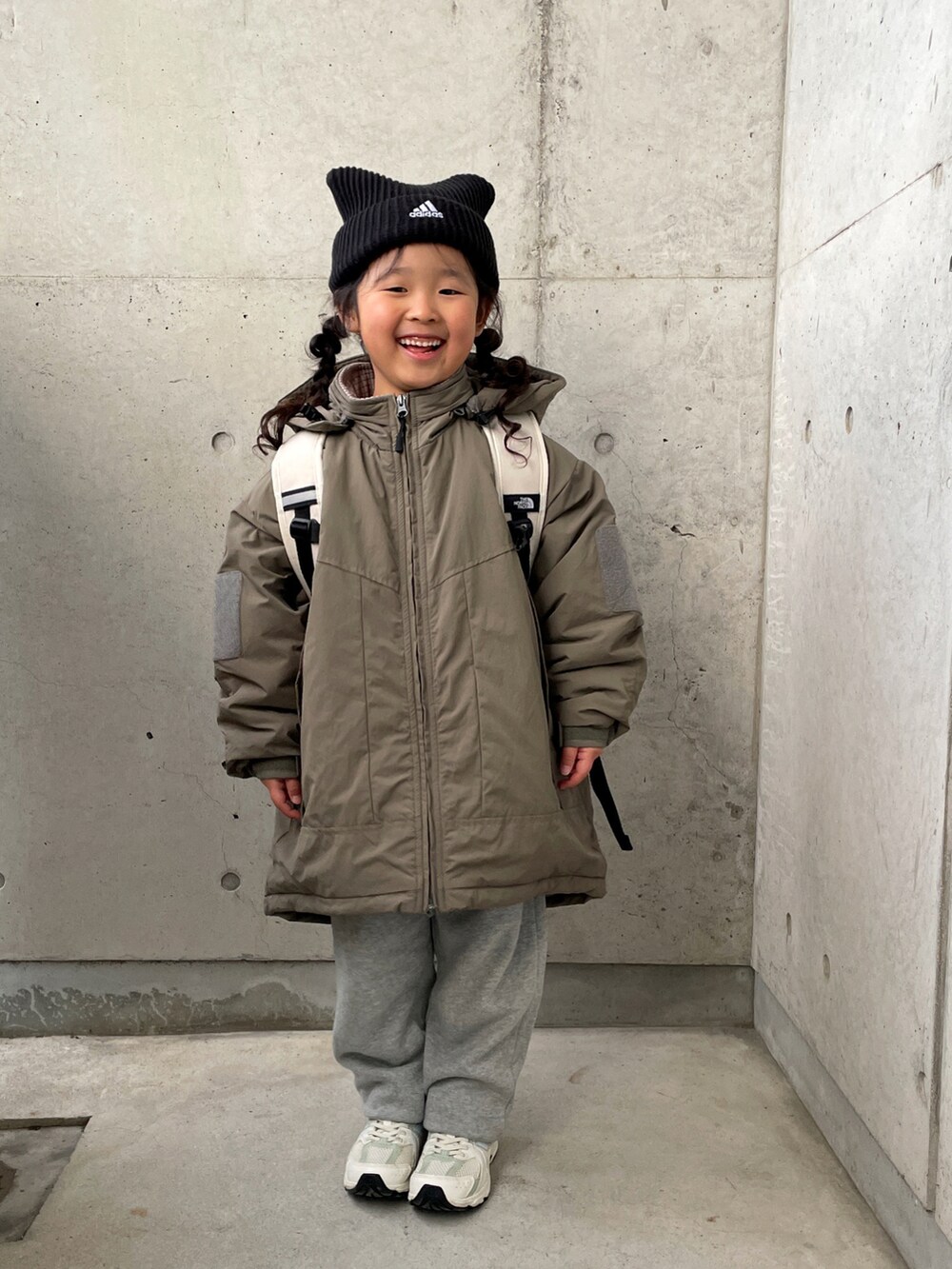 グリーン系のブルゾン、ホワイト系のバックパック/リュック、グレー系のパンツを着用したキッズの冬コーディネートの4枚目の写真