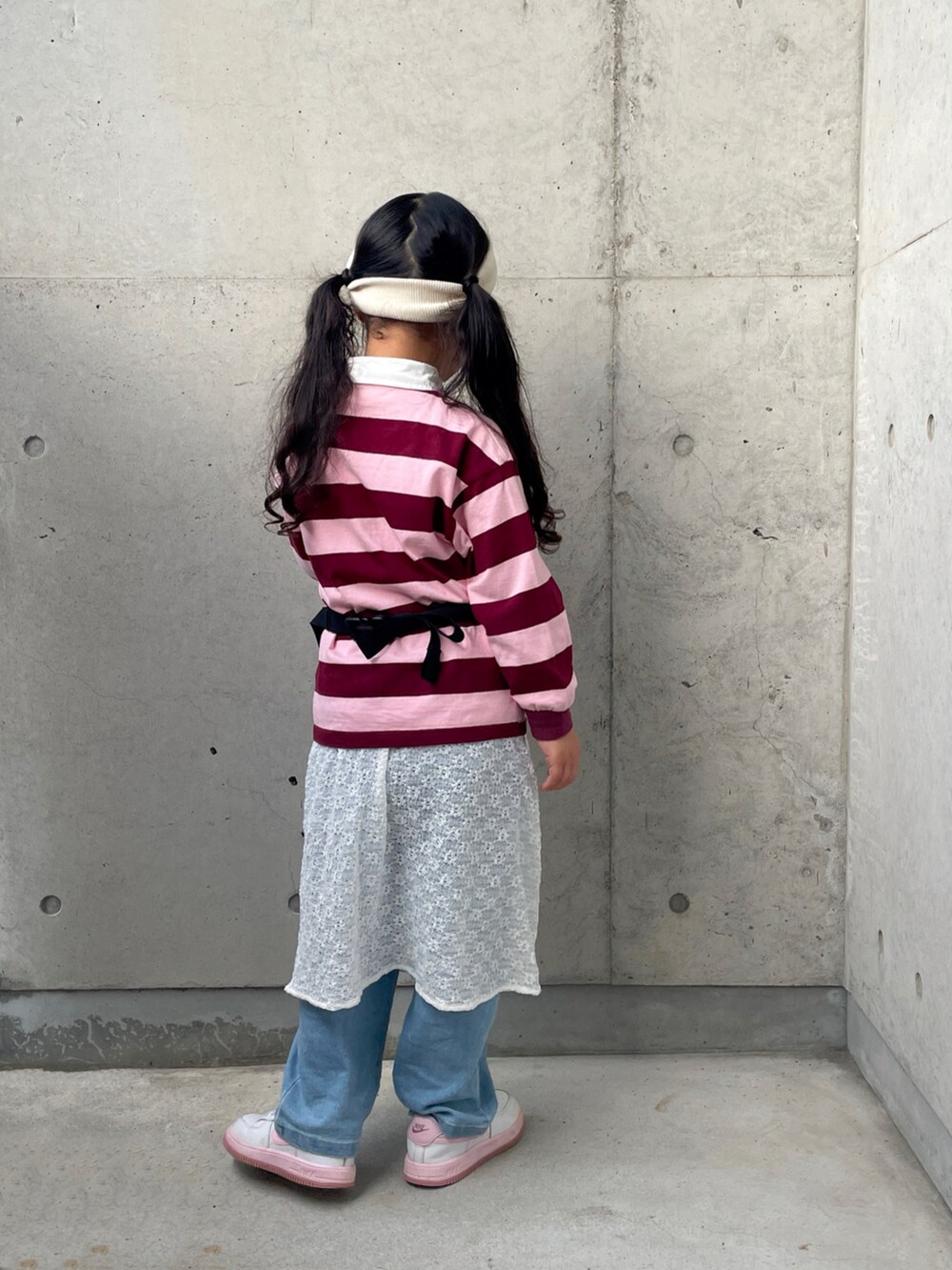 ブラック系のボディバッグ/ウエストポーチ、ピンク系のTシャツ/カットソー、ホワイト系のスニーカーを着用したキッズの秋コーディネートの3枚目の写真