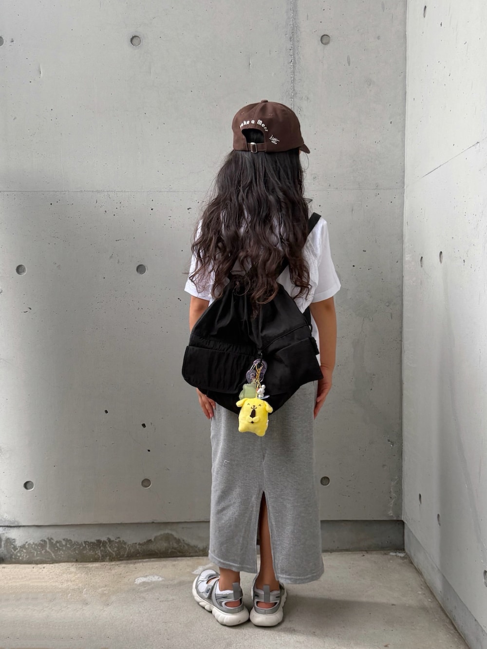 グレー系のスカート、シルバー系のスニーカー、ホワイト系のTシャツ/カットソーを着用したキッズの夏コーディネートの2枚目の写真