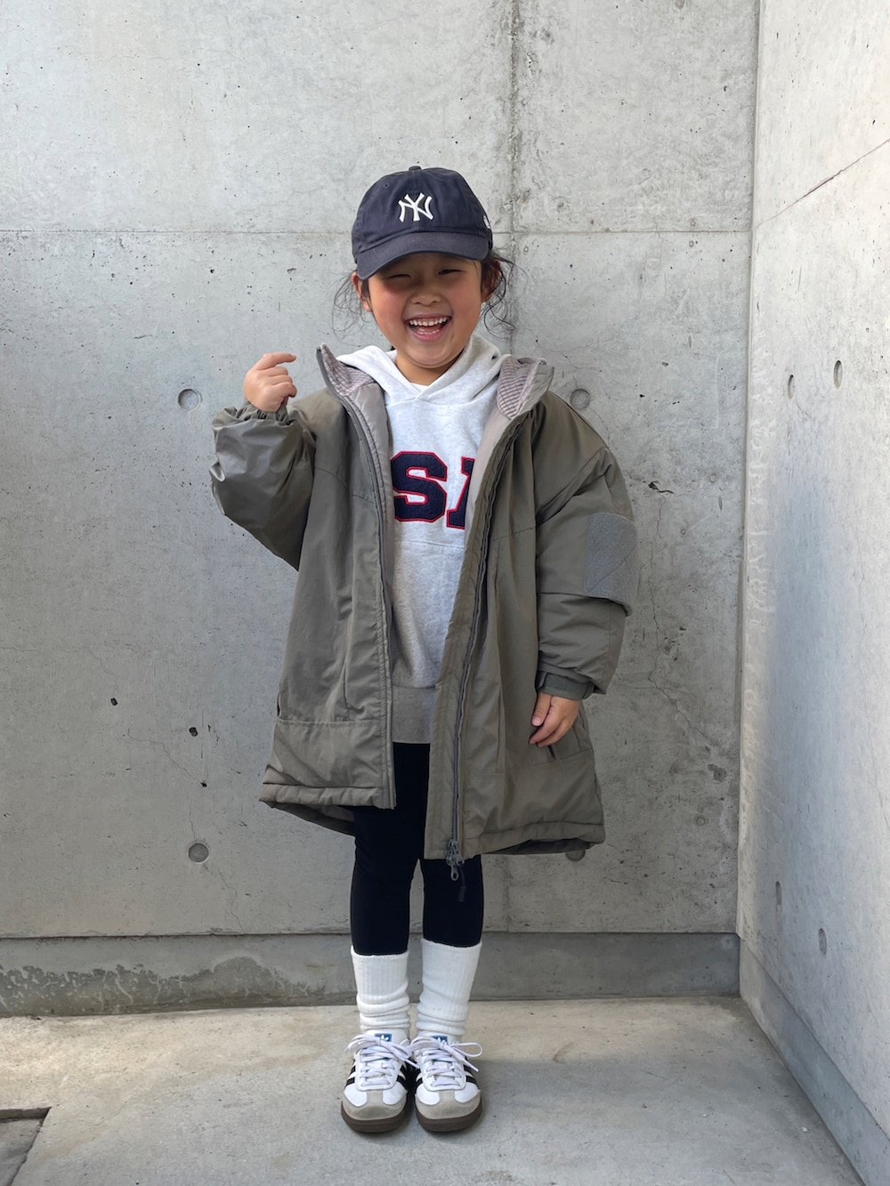 グリーン系のブルゾン、ホワイト系のTシャツ/カットソー、グレー系のスウェットを着用したキッズの冬コーディネートの3枚目の写真