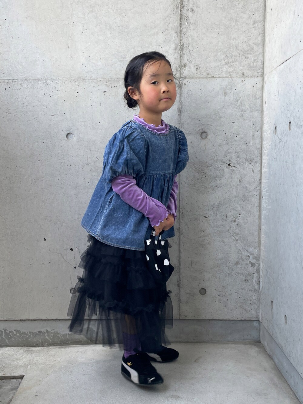 ブラック系のスニーカー、ブラック系のスカート、パープル系のTシャツ/カットソーを着用したキッズの春コーディネートの2枚目の写真