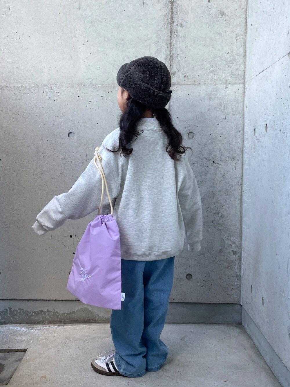 パープル系のエコバッグ/サブバッグ、グレー系のスウェット、ブルー系のデニムパンツを着用したキッズの冬コーディネートの3枚目の写真