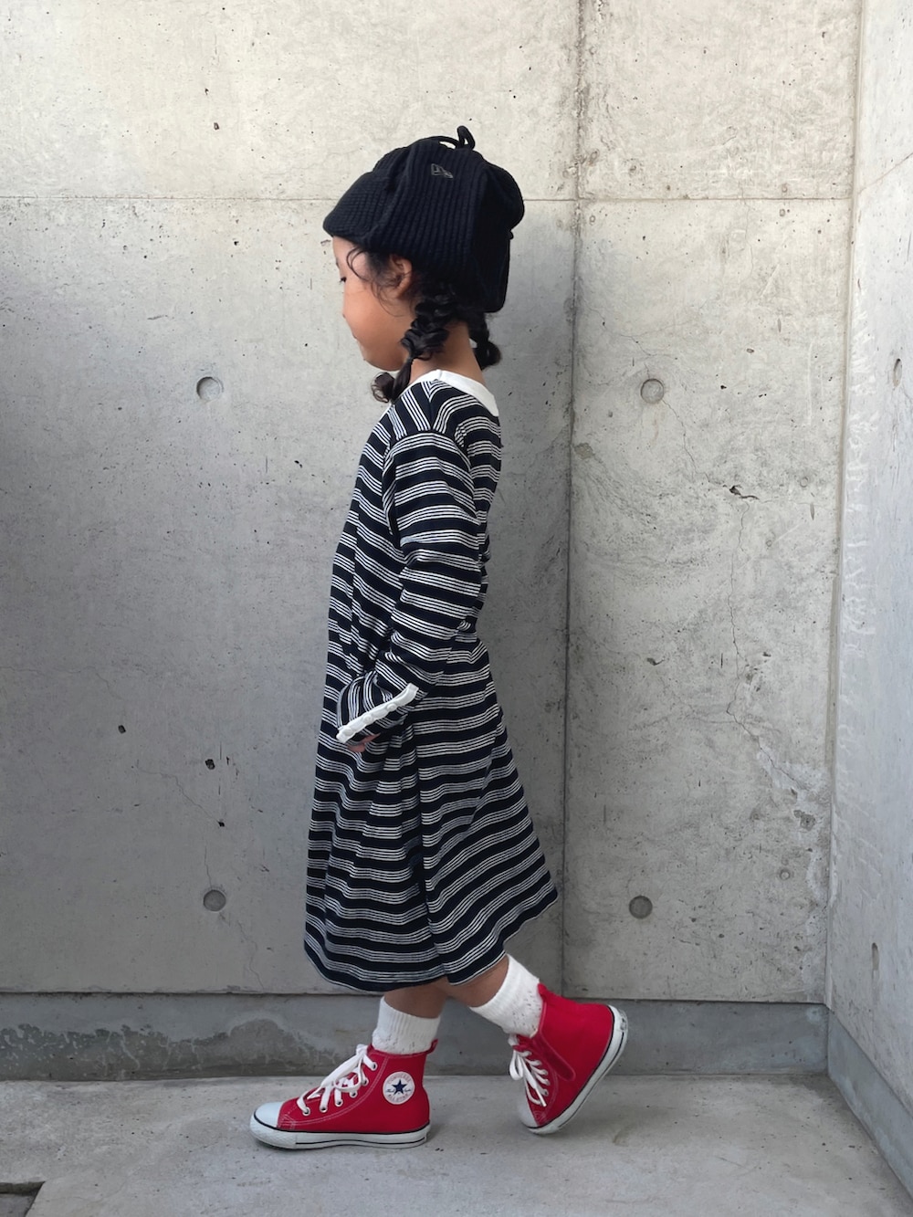 ブルー系のデニムジャケット、ブラック系のワンピース、レッド系のスニーカーを着用したキッズの秋コーディネートの3枚目の写真