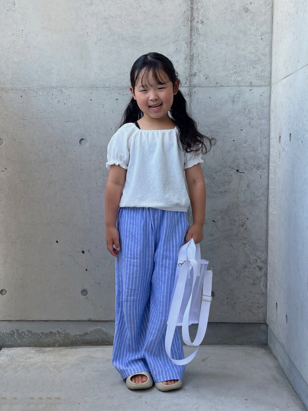 ベージュ系のサンダル、ブラック系のキャミソール、ホワイト系のトップスを着用したキッズの夏コーディネートの5枚目の写真