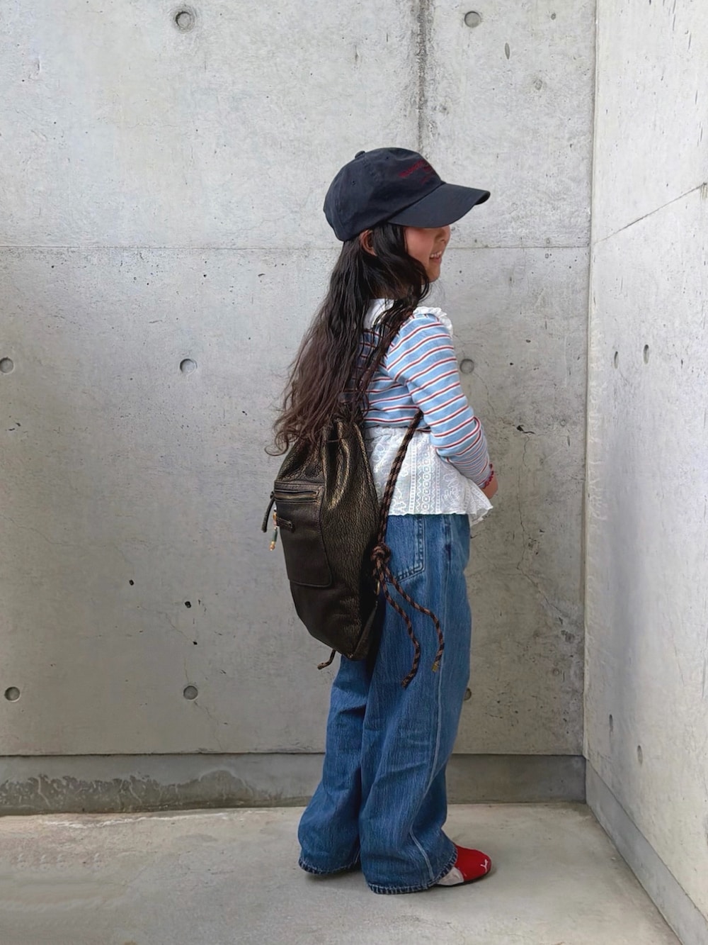 ブラック系のスカート、レッド系のスニーカー、ブラック系のバックパック/リュックを着用したキッズの春コーディネートの4枚目の写真