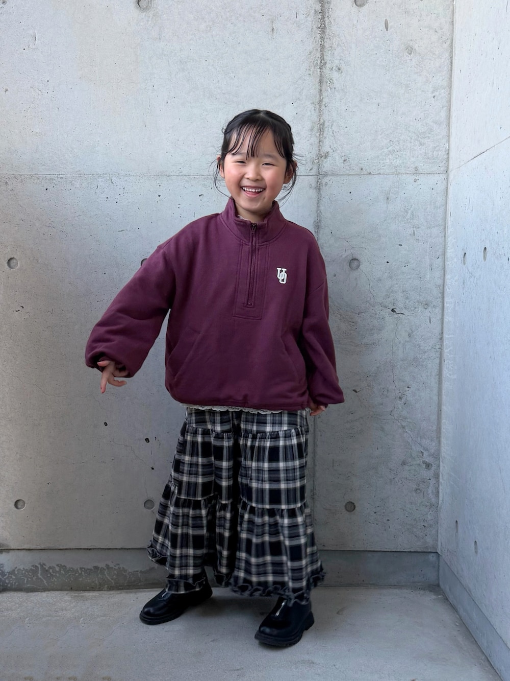 ブラウン系のブルゾン、ブラウン系のスカート、レッド系のスウェットを着用したキッズの冬コーディネートの4枚目の写真