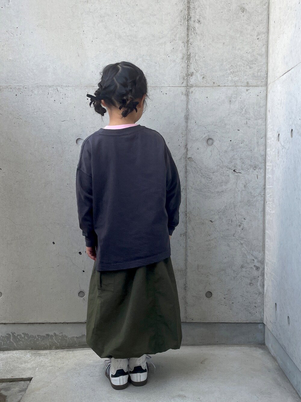 ホワイト系のスニーカー、グリーン系のスカート、グレー系のTシャツ/カットソーを着用したキッズの春コーディネートの3枚目の写真