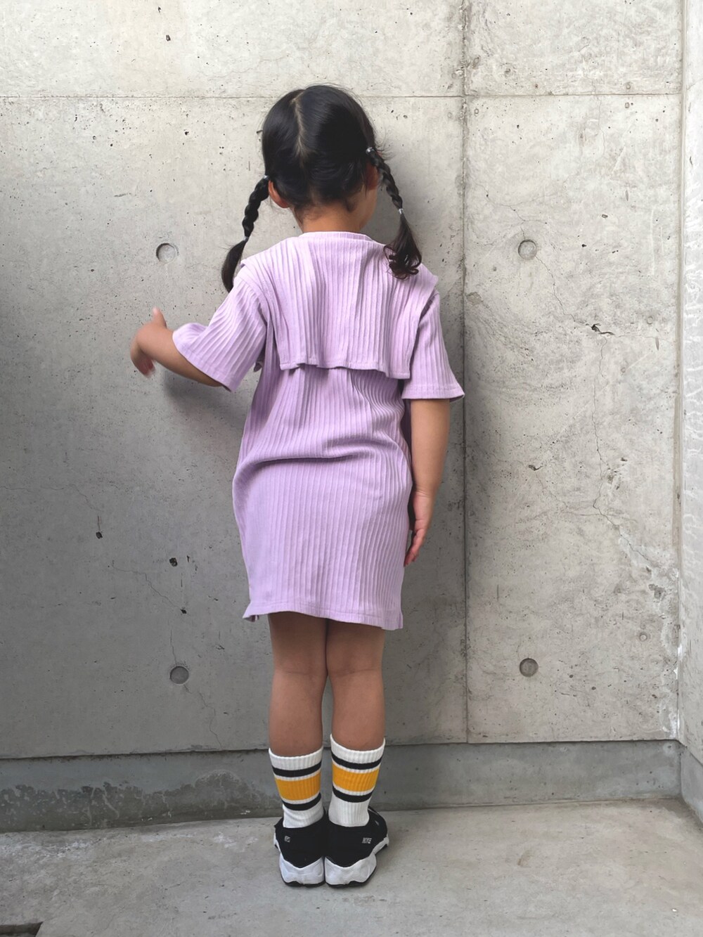 パープル系のワンピース、ブラック系のスニーカー、ベージュ系のハットを着用したキッズの春コーディネートの4枚目の写真