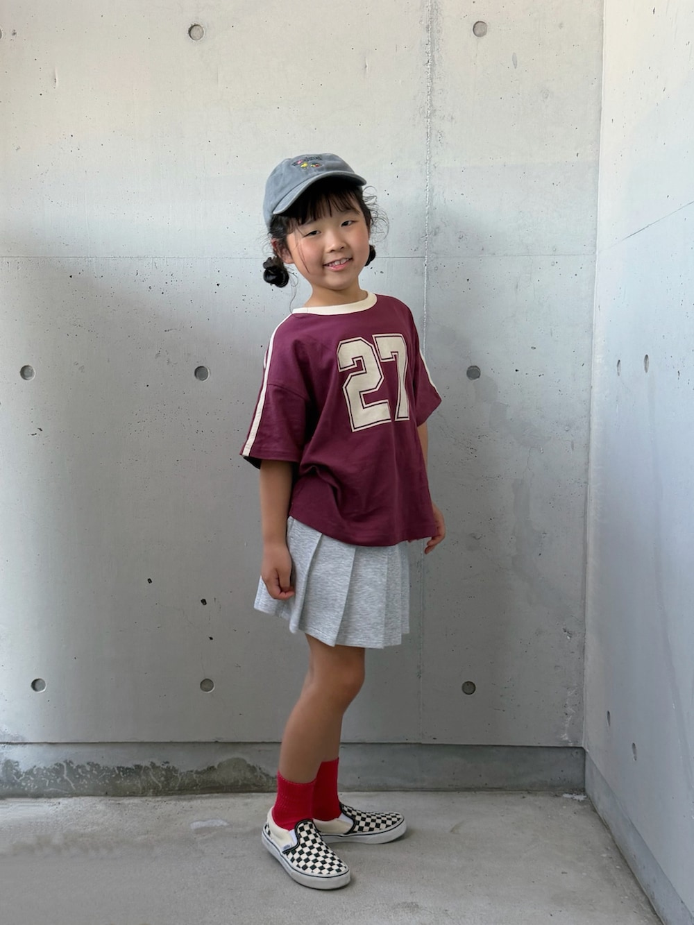 レッド系のTシャツ/カットソー、ブラック系のスリッポン、グレー系のスカートを着用したキッズの夏コーディネートの2枚目の写真