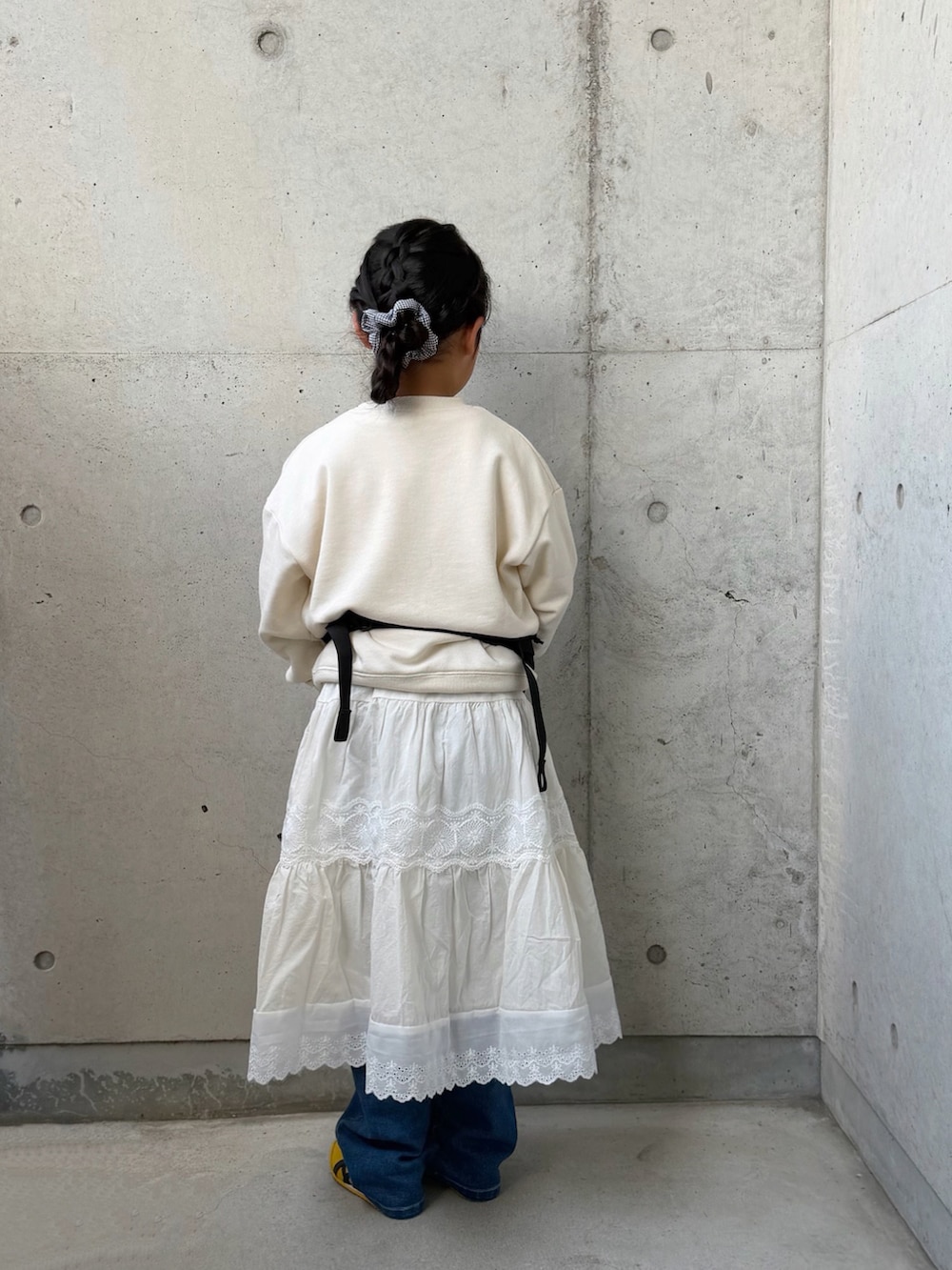 ホワイト系のスウェット、ブルー系のデニムパンツ、ブラック系のボディバッグ/ウエストポーチを着用したキッズの春コーディネートの2枚目の写真