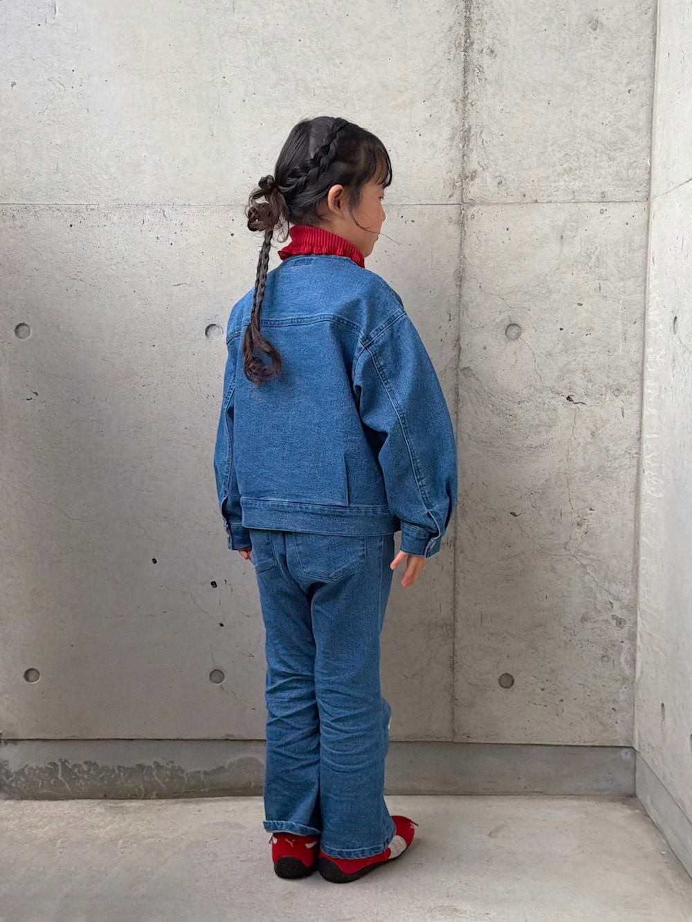 レッド系のニット/セーター、レッド系のスニーカー、ブルー系のデニムジャケットを着用したキッズの冬コーディネートの5枚目の写真