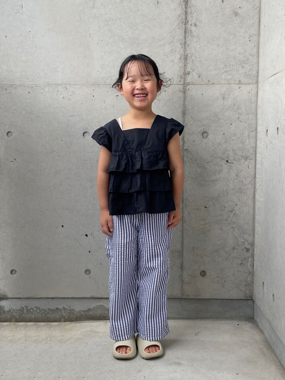 ホワイト系のキャミソール、ベージュ系のサンダル、ブラック系のシャツ/ブラウスを着用したキッズの夏コーディネートの5枚目の写真