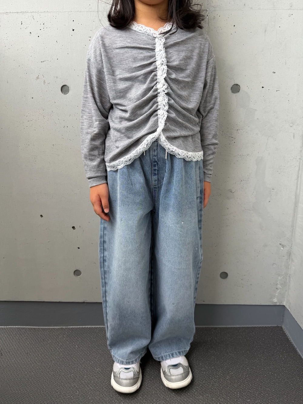 グレー系のTシャツ/カットソー、ブルー系のデニムパンツ、シルバー系のスニーカーを着用したキッズの秋コーディネートの4枚目の写真