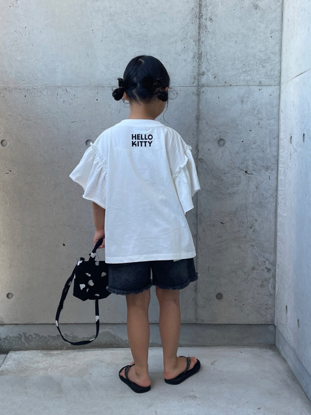 ブラック系のデニムパンツ、ブラック系のサンダル、ブラック系のショルダーバッグを着用したキッズの夏コーディネートの4枚目の写真