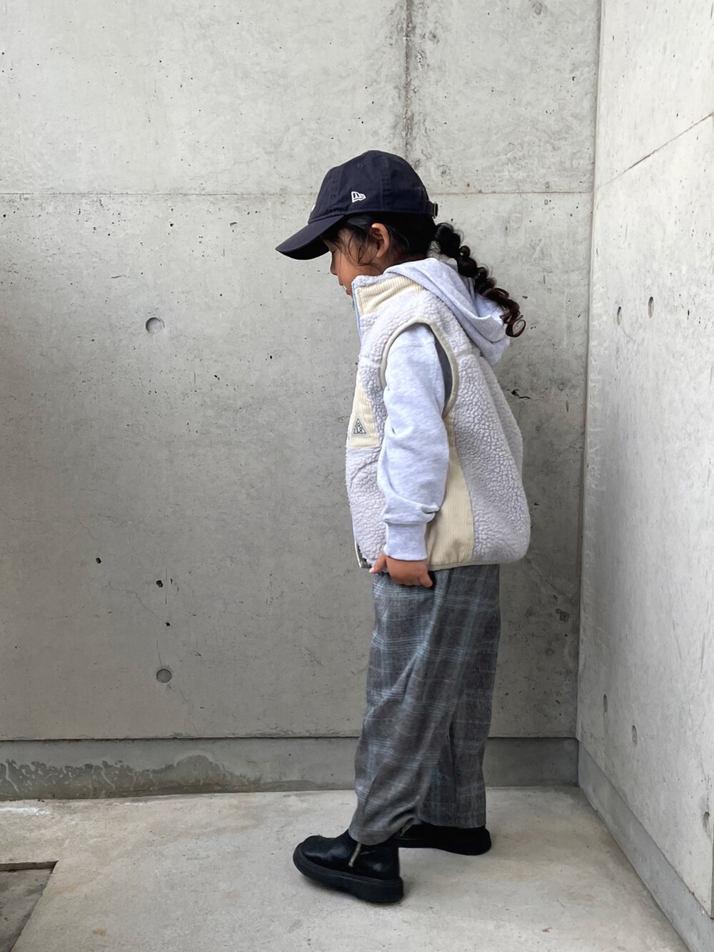 グレー系のベスト、グレー系のスウェット、グレー系のパンツを着用したキッズの冬コーディネートの3枚目の写真