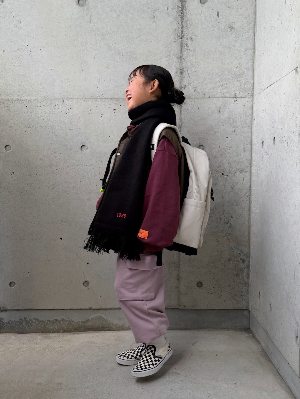 ホワイト系のTシャツ/カットソー、ピンク系のカーゴパンツ、ブラック系のスリッポンを着用したキッズの冬コーディネートの5枚目の写真