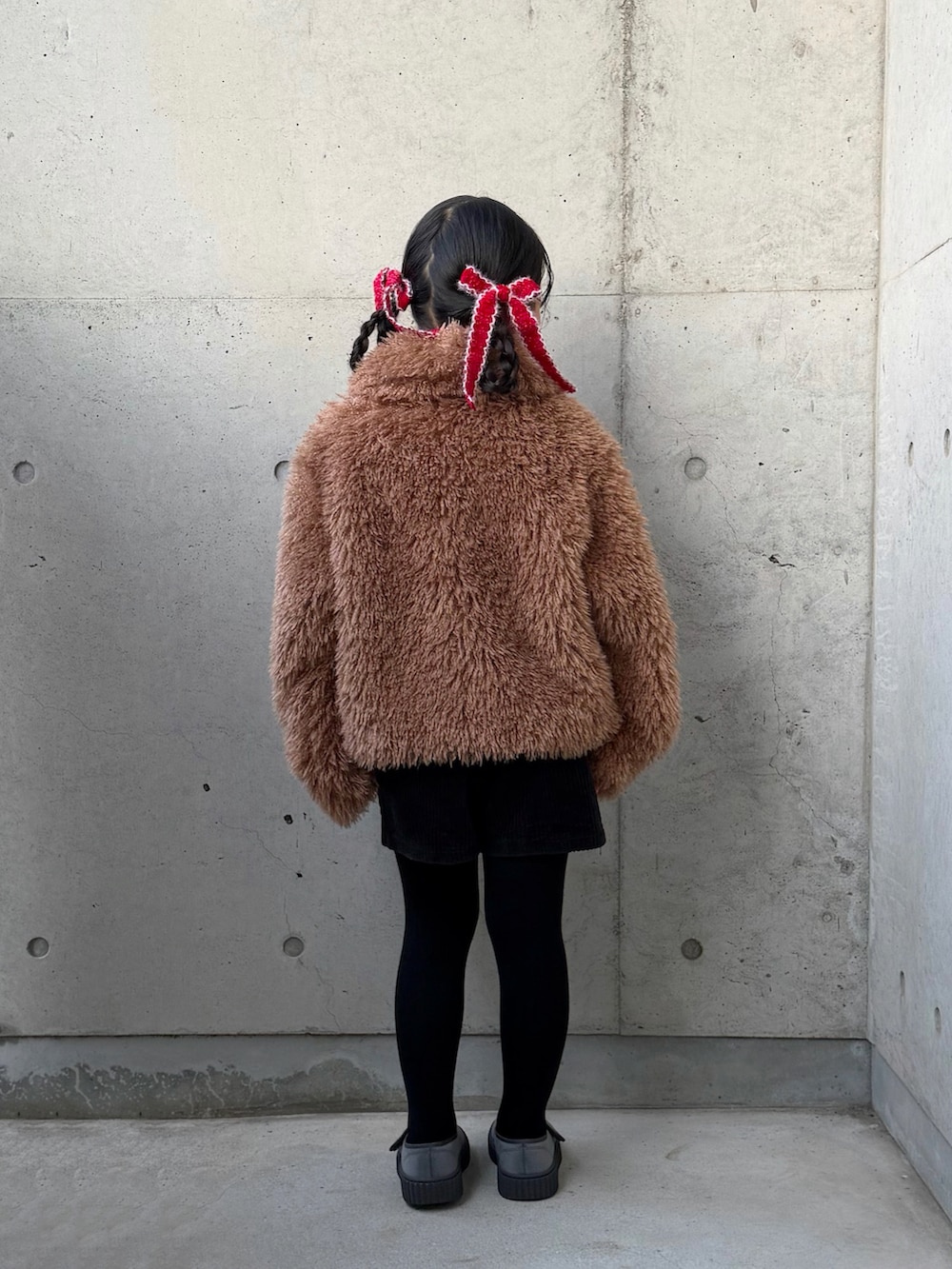 レッド系のニット/セーター、ブラック系のその他パンツ、ブラウン系のブルゾンを着用したキッズの冬コーディネートの4枚目の写真