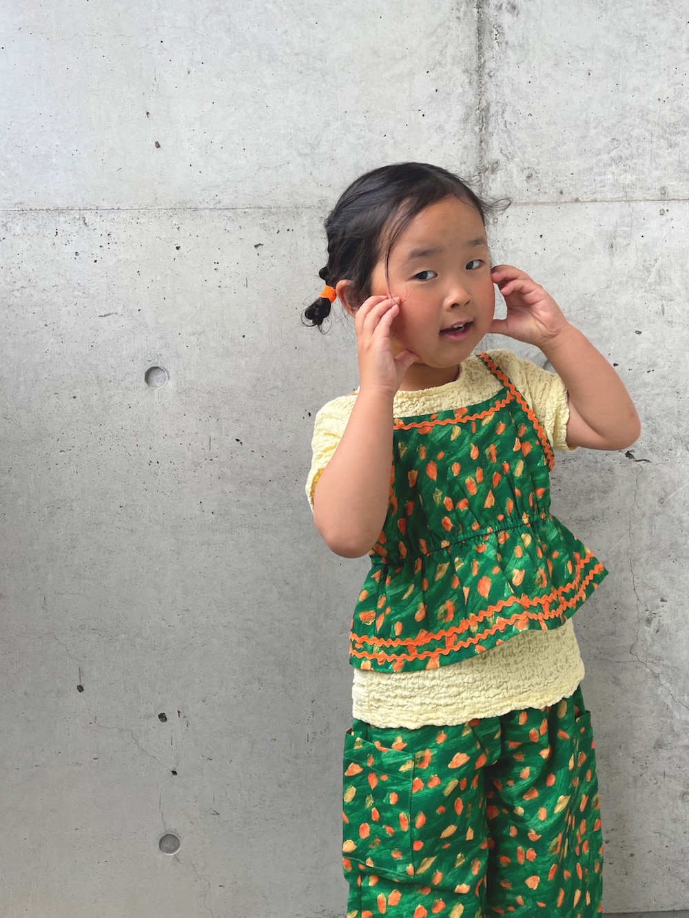 グリーン系のキャミソール、グリーン系のその他パンツ、ベージュ系のTシャツ/カットソーを着用したキッズの春コーディネートの5枚目の写真