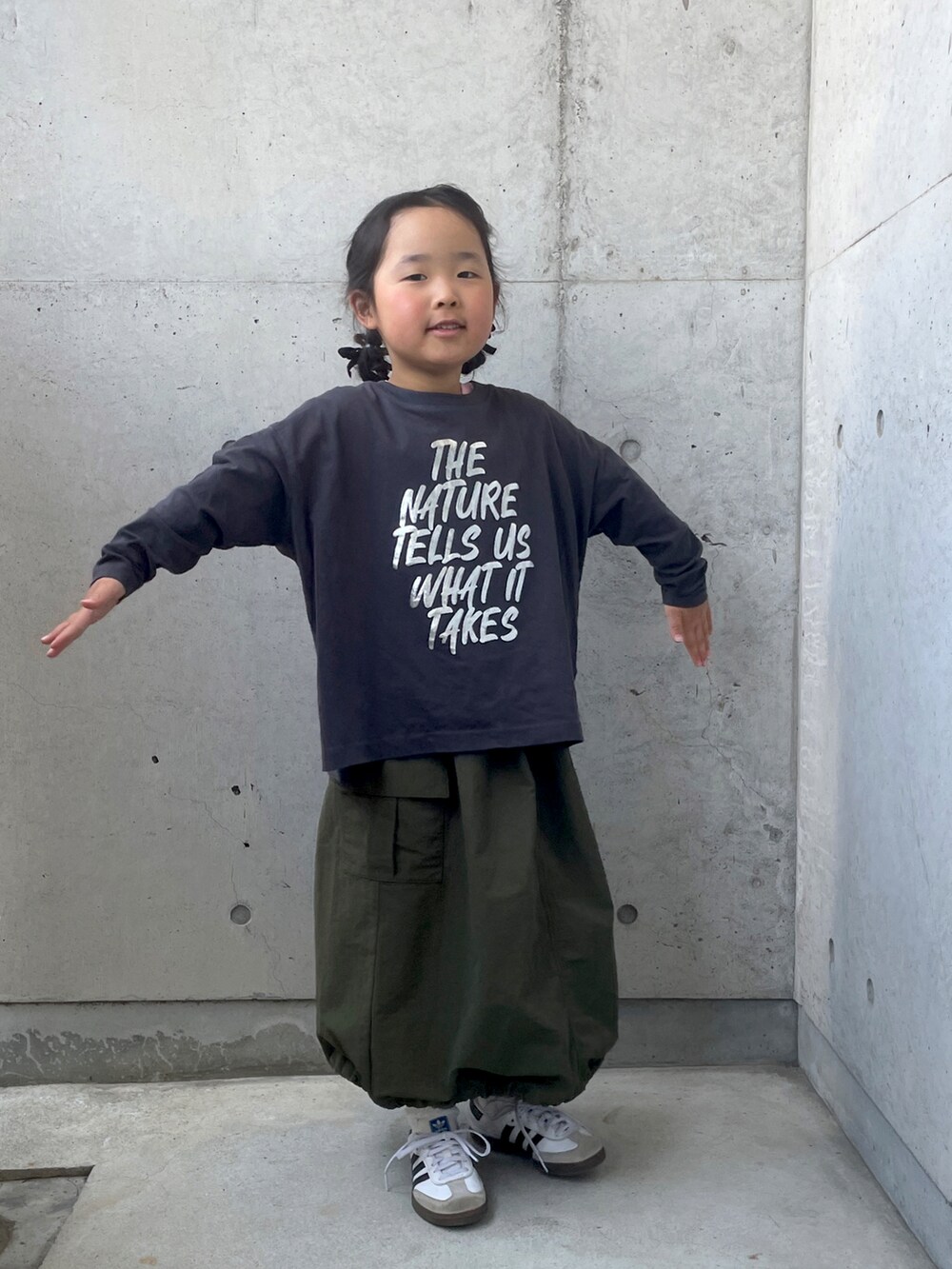 ホワイト系のスニーカー、グリーン系のスカート、グレー系のTシャツ/カットソーを着用したキッズの春コーディネートの5枚目の写真