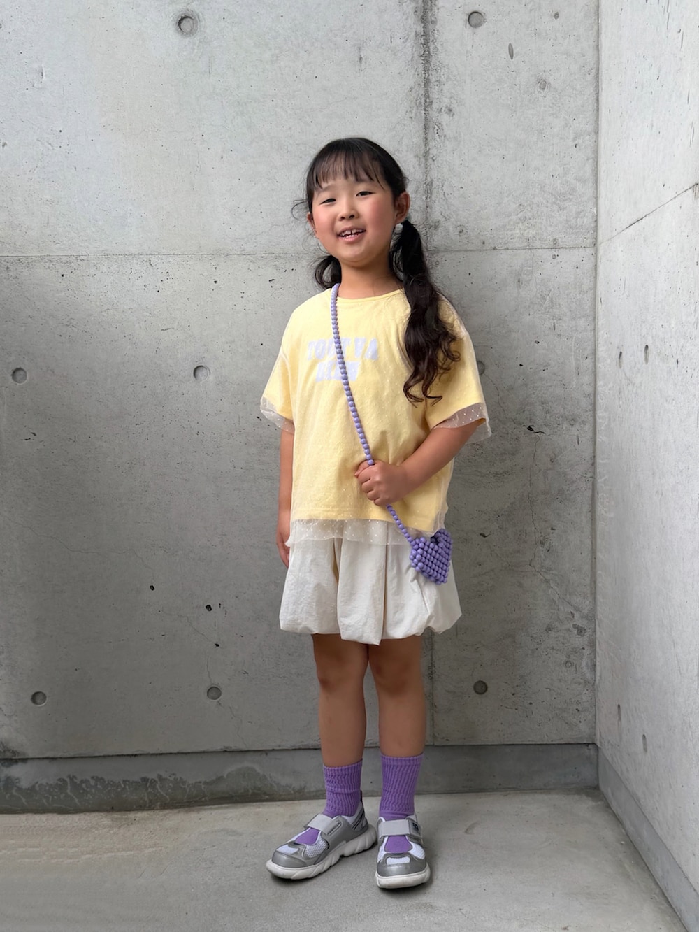イエロー系のTシャツ/カットソー、ホワイト系のその他パンツ、シルバー系のスニーカーを着用したキッズの春コーディネートの5枚目の写真