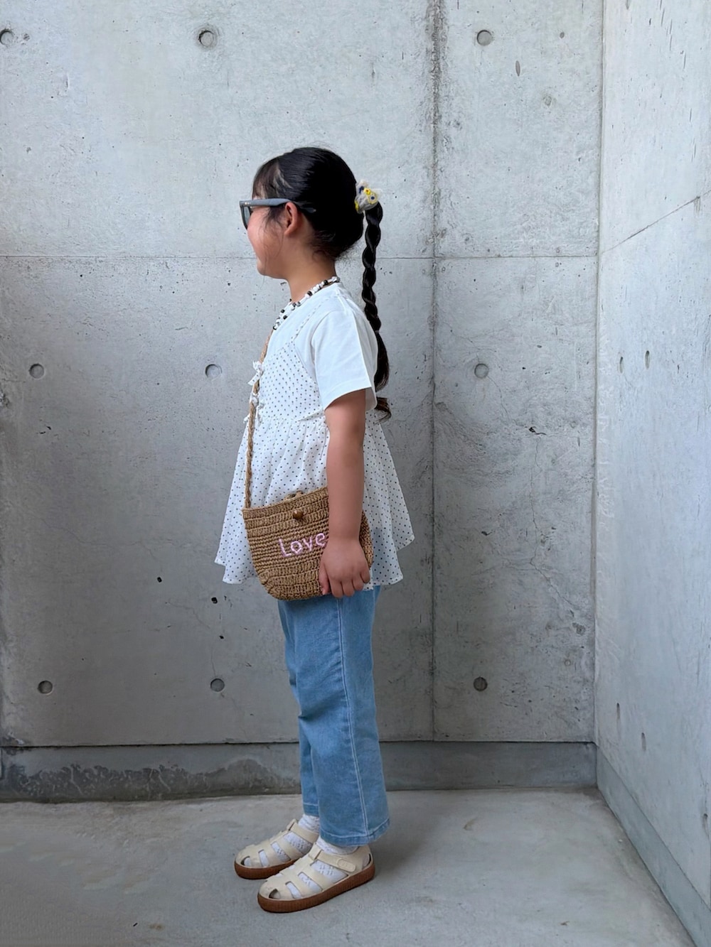 ブルー系のデニムパンツ、ホワイト系のTシャツ/カットソー、ベージュ系のショルダーバッグを着用したキッズの春コーディネートの2枚目の写真
