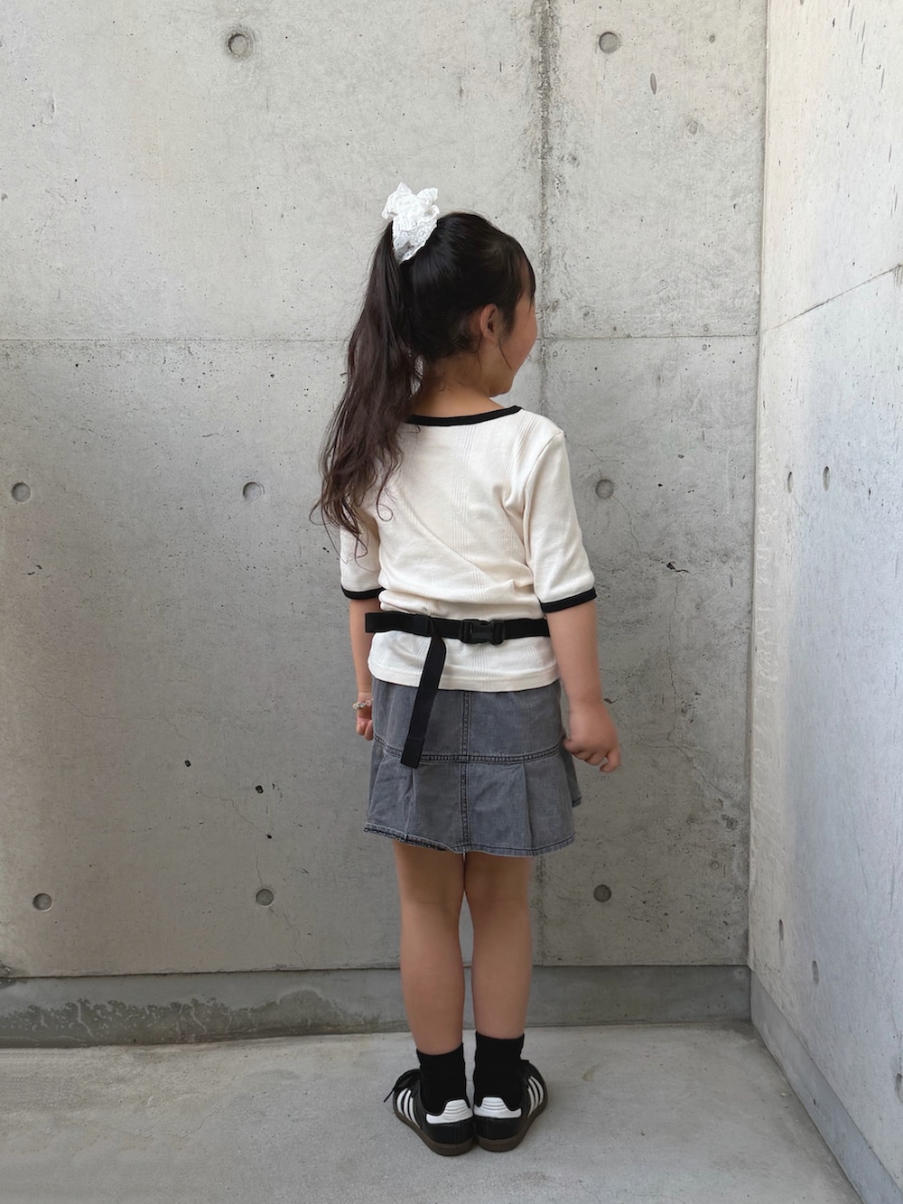 ブラック系のボディバッグ/ウエストポーチ、ホワイト系のTシャツ/カットソー、グレー系のスカートを着用したキッズの春コーディネートの3枚目の写真