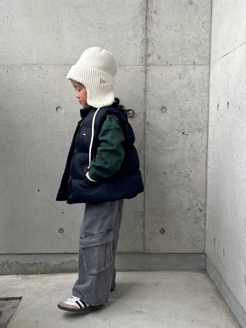 ブラック系のパンツ、ブラック系のダウンベスト、グリーン系のスウェットを着用したキッズの冬コーディネートの2枚目の写真