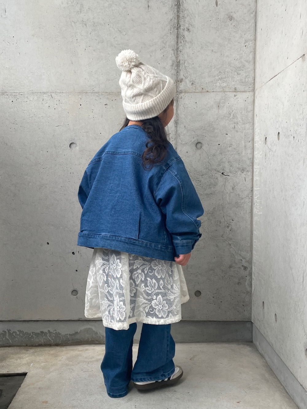 ブルー系のデニムジャケット、ホワイト系のスウェット、ホワイト系のスカートを着用したキッズの冬コーディネートの5枚目の写真