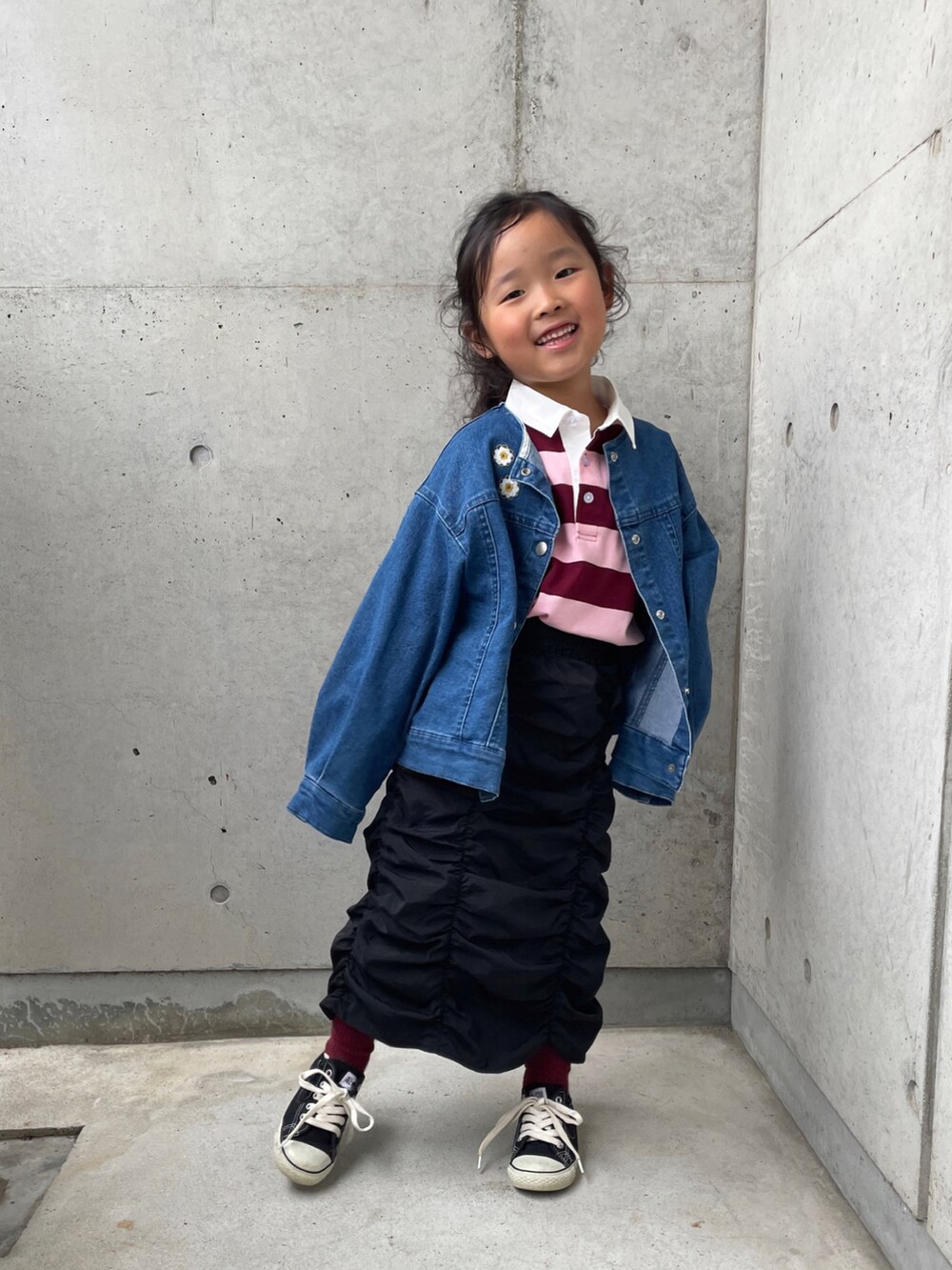 ピンク系のTシャツ/カットソー、ブルー系のデニムジャケット、ブラック系のスカートを着用したキッズの秋コーディネートの5枚目の写真