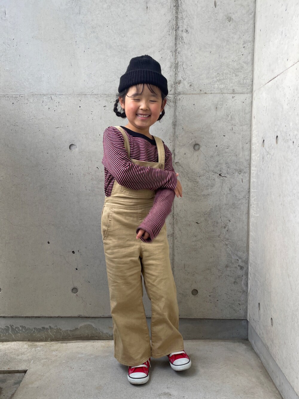 レッド系のスニーカー、レッド系のTシャツ/カットソー、ベージュ系のサロペット/オーバーオールを着用したキッズの春コーディネートの4枚目の写真