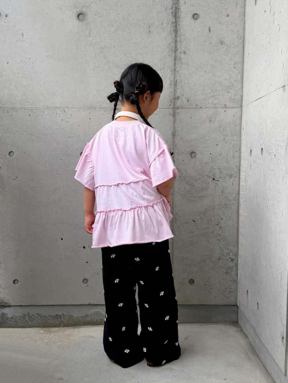 ピンク系のTシャツ/カットソー、ブラック系のその他パンツ、ベージュ系のサンダルを着用したキッズの春コーディネートの5枚目の写真