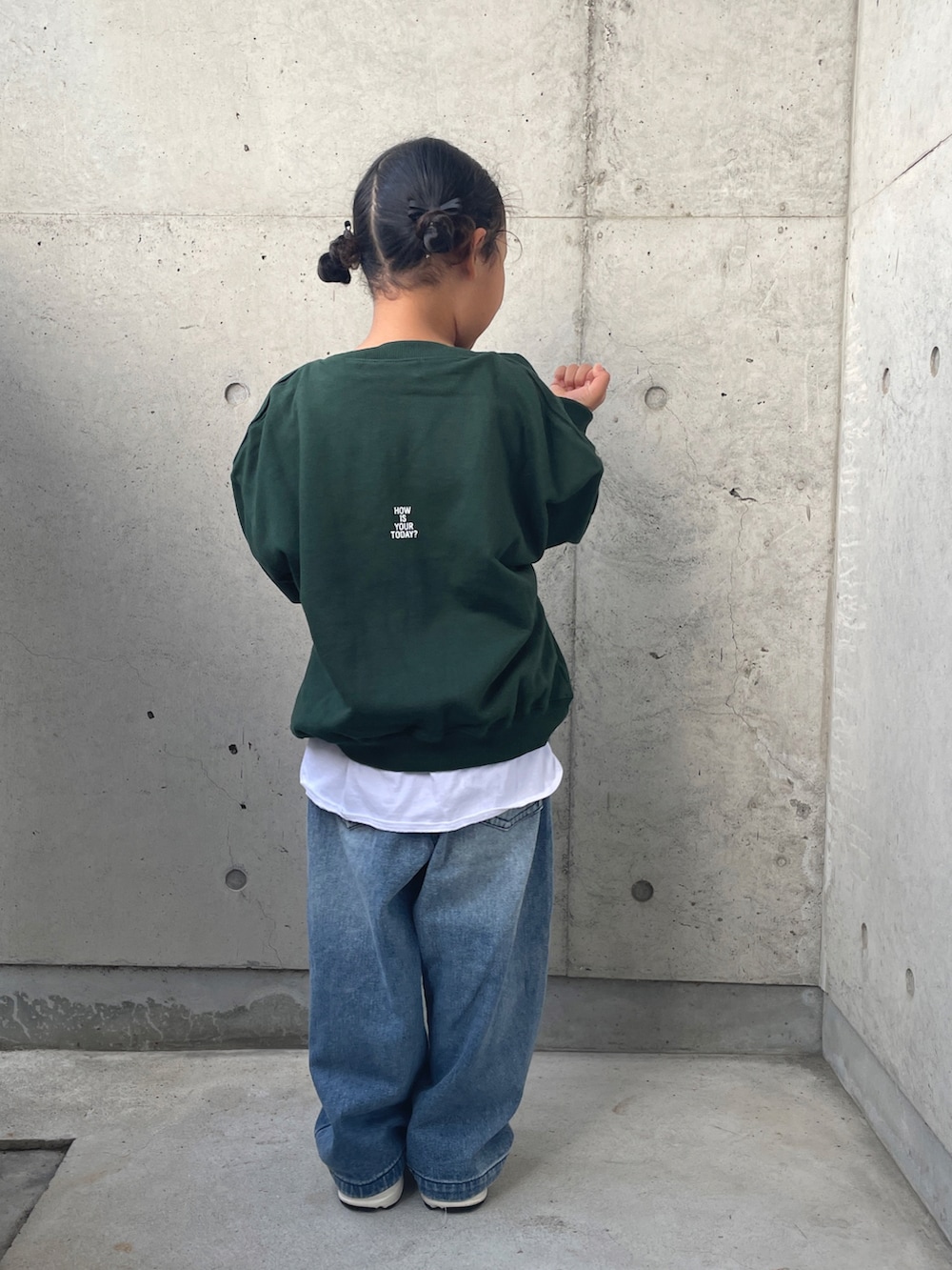 グリーン系のスウェット、ブルー系のデニムパンツ、ホワイト系のスニーカーを着用したキッズの秋コーディネートの2枚目の写真