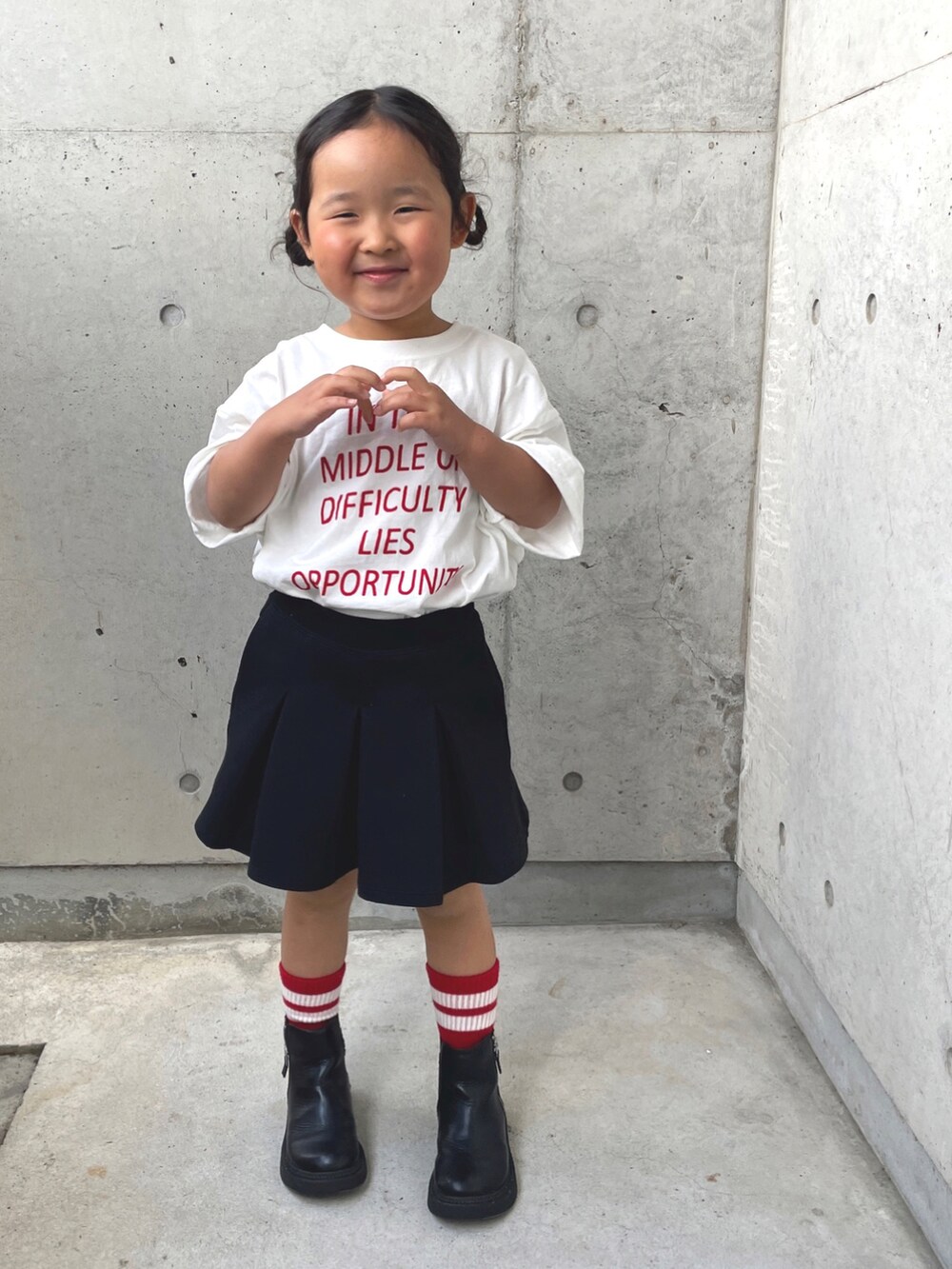 ホワイト系のTシャツ/カットソー、ブラック系のスカート、ブラック系のブーツを着用したキッズの春コーディネートの2枚目の写真