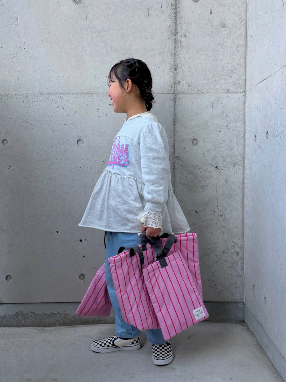 ホワイト系のTシャツ/カットソー、グレー系のワンピース、ピンク系のトートバッグを着用したキッズの冬コーディネートの5枚目の写真