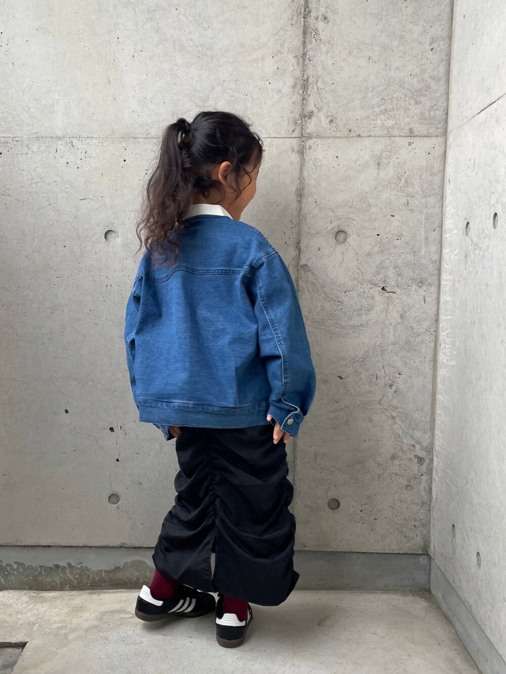 ピンク系のTシャツ/カットソー、ブルー系のデニムジャケット、ブラック系のスカートを着用したキッズの秋コーディネートの4枚目の写真