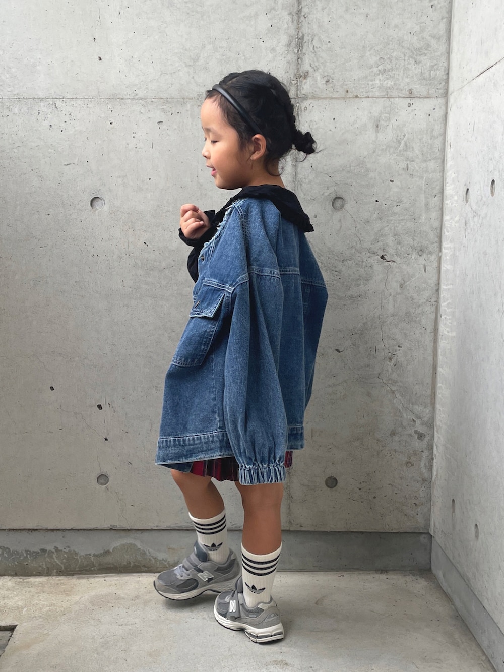 グレー系のスニーカー、ブラック系のトップス、ブルー系のデニムジャケットを着用したキッズの秋コーディネートの3枚目の写真