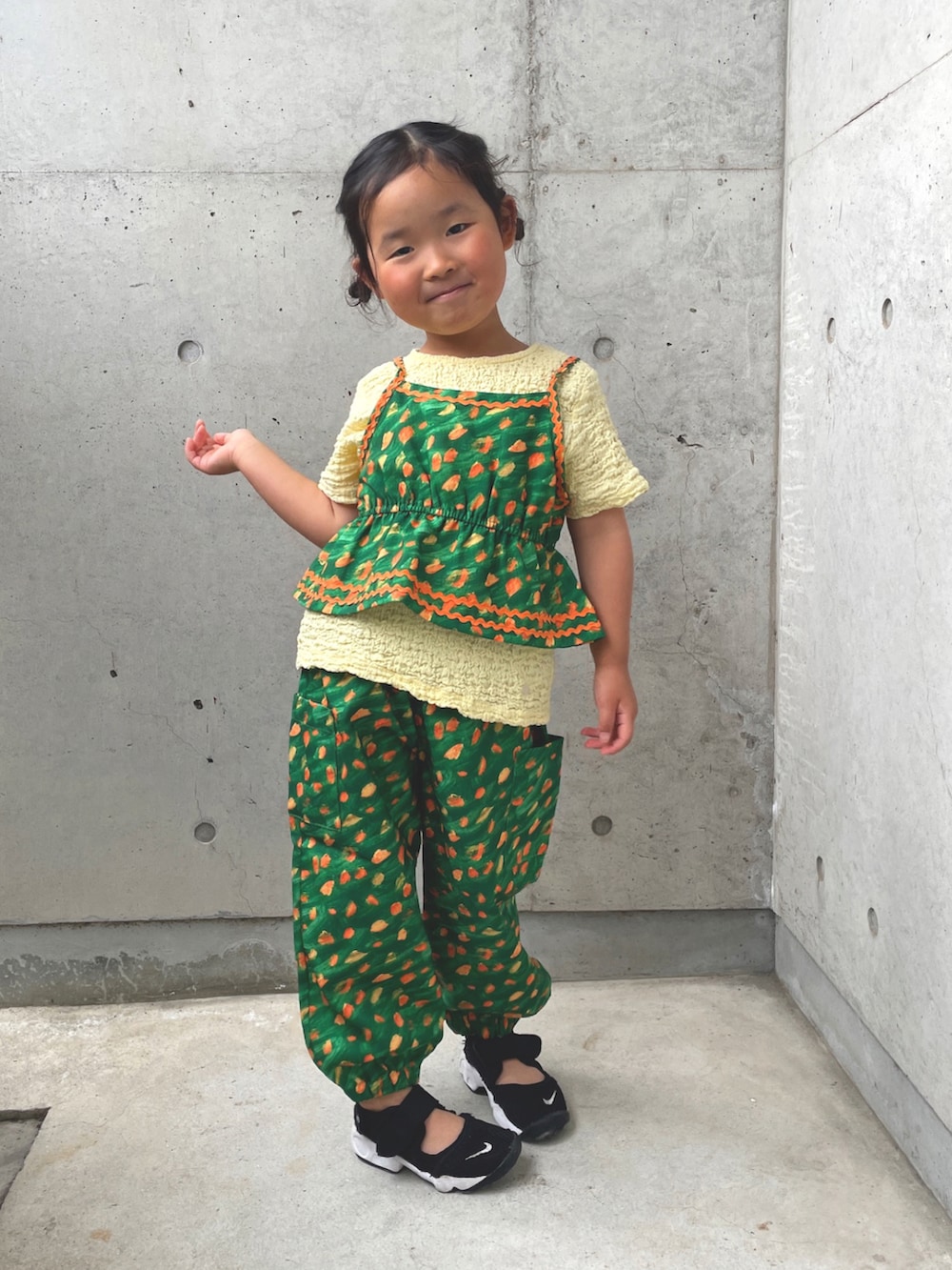 グリーン系のキャミソール、グリーン系のその他パンツ、ベージュ系のTシャツ/カットソーを着用したキッズの春コーディネートの2枚目の写真