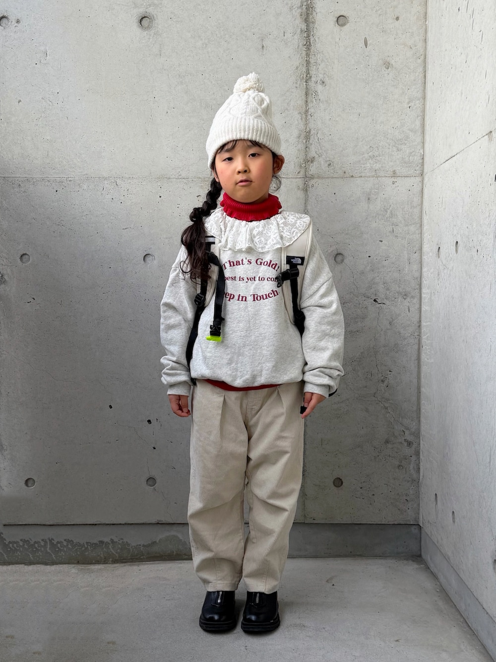 ベージュ系のスウェット、レッド系のニット/セーター、ベージュ系のその他パンツを着用したキッズの冬コーディネートの3枚目の写真
