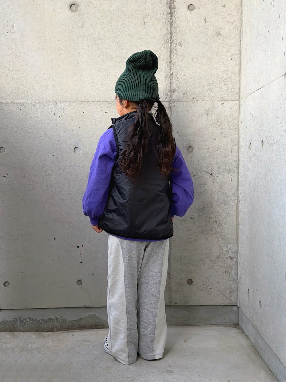パープル系のTシャツ/カットソー、グレー系のスウェットパンツ、ブラック系のベストを着用したキッズの冬コーディネートの3枚目の写真