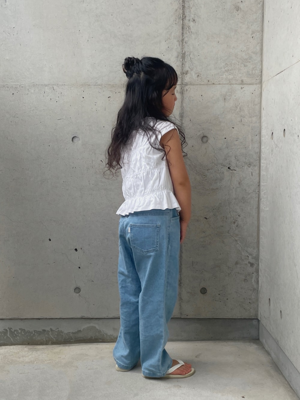 ホワイト系のサンダル、ブルー系のデニムパンツ、ホワイト系のトップスを着用したキッズの夏コーディネートの2枚目の写真