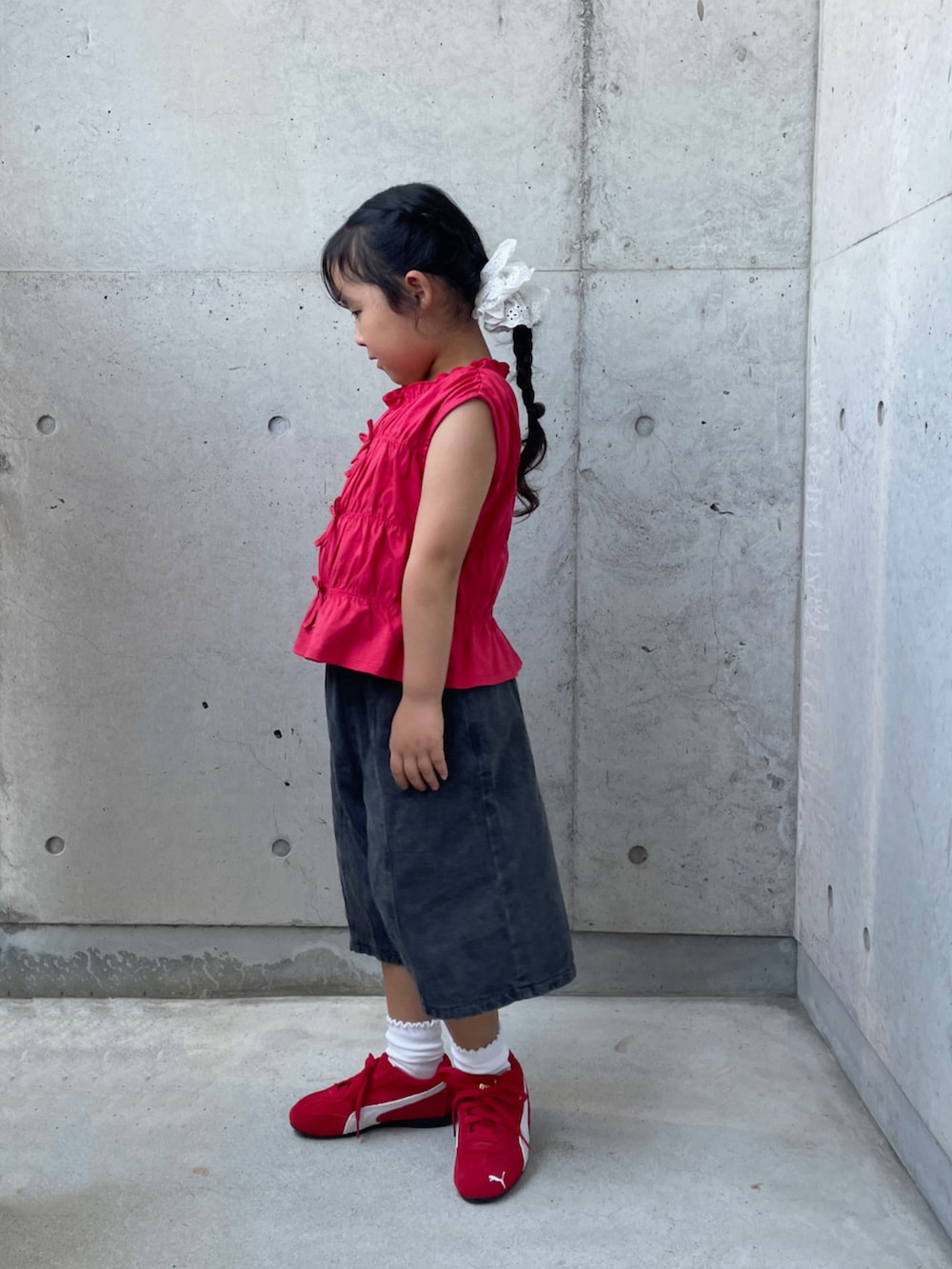 ブラック系のデニムパンツ、レッド系のスニーカー、レッド系のトップスを着用したキッズの夏コーディネートの4枚目の写真