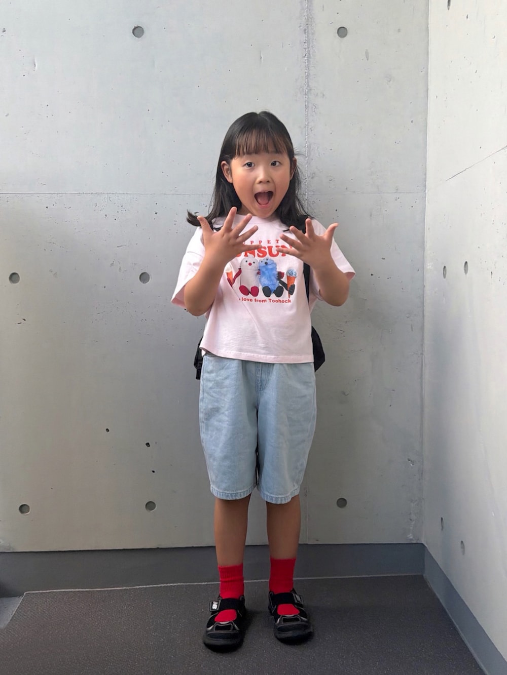 ブラック系のサンダル、ブラック系のバックパック/リュック、ピンク系のTシャツ/カットソーを着用したキッズの秋コーディネートの3枚目の写真